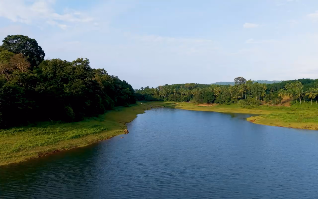 Vue aérienne d'un plan d'eau bordé de terres rouges et de végétation.