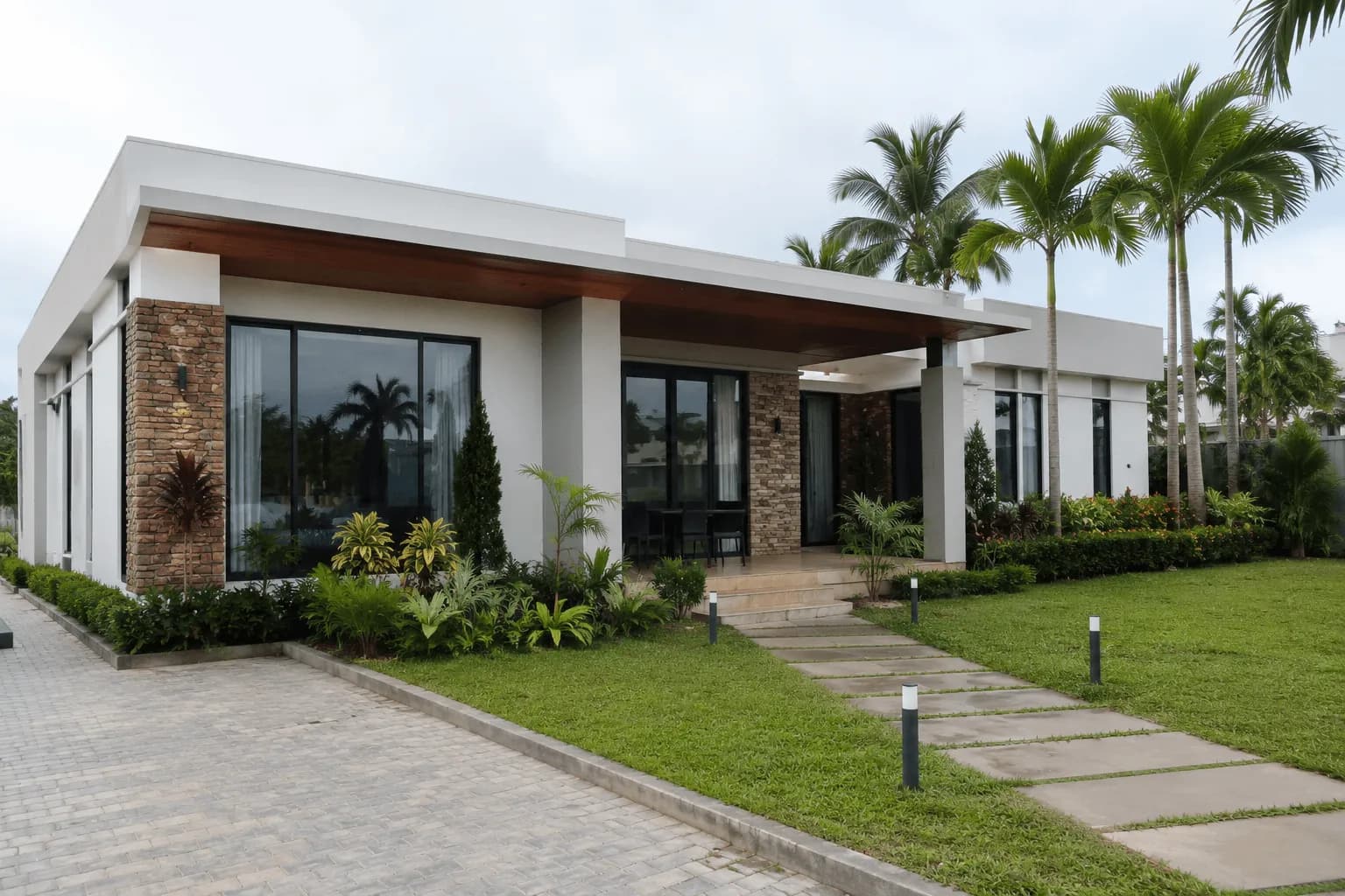 Villa contemporaine de plain-pied, allée dallée et pelouse.
