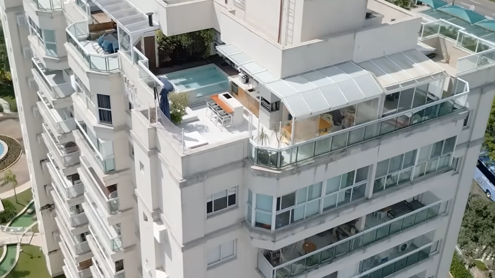 Tour vue du ciel : une piscine sur son toit-terrasse, entre la cuisine d'été et le salon vitré.