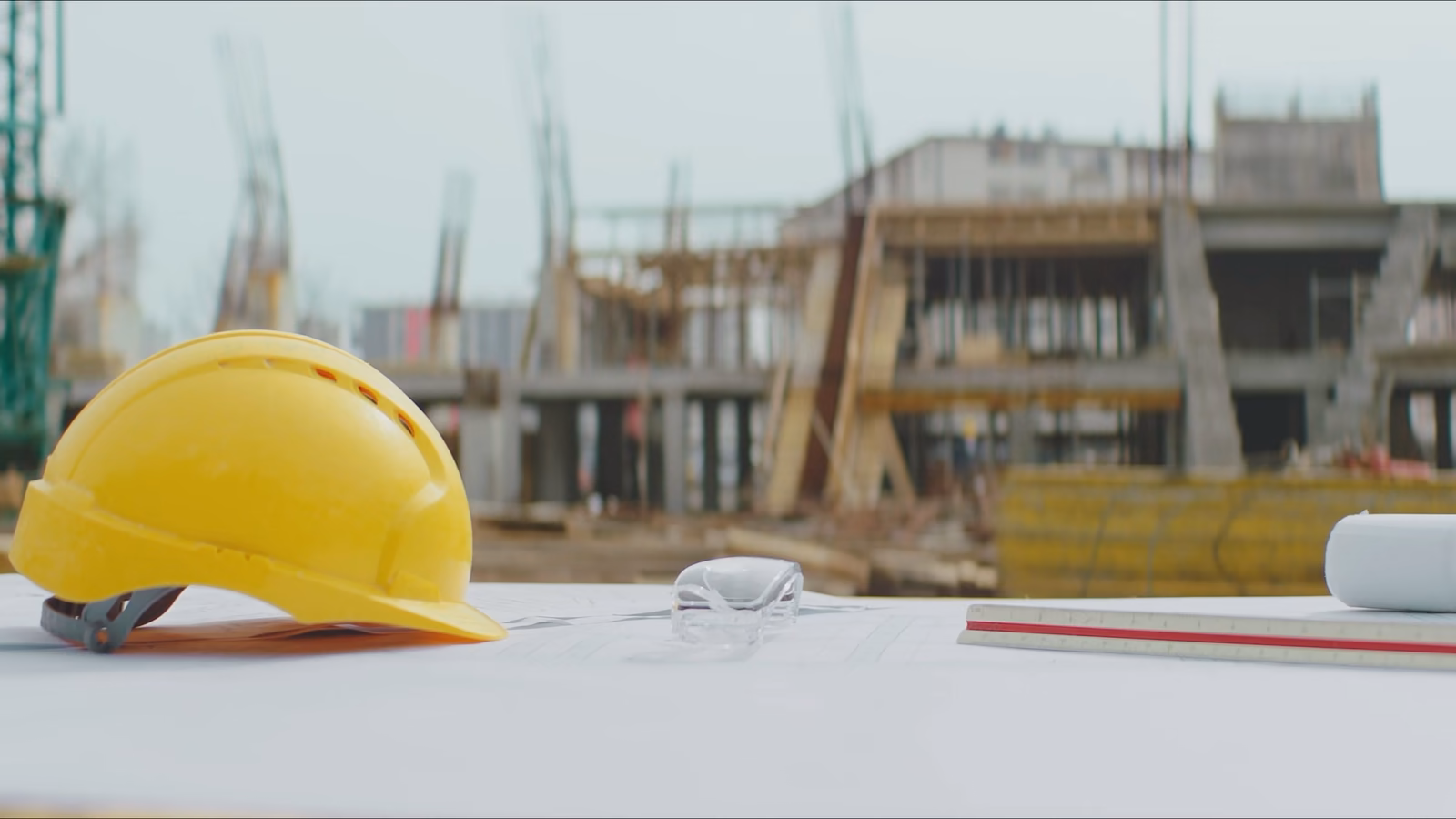 Des plans et un casque de chantier, la maquette d'une résidence, le béton coulé sur le ferraillage, puis une villa avec piscine et son salon.