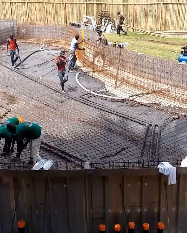 Chantier d'une grande piscine monobloc en Côte d'Ivoire : le ferraillage du fond, l'équipe au travail dans le bassin, puis la cage ronde.