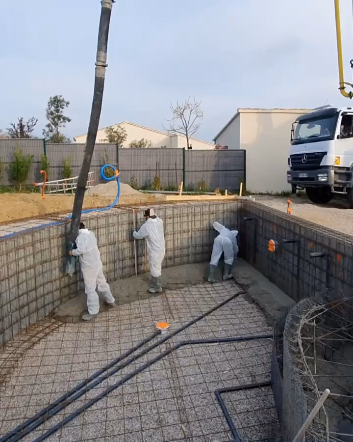 Chantier d'une piscine monobloc en France : le fond et les marches du bassin ferraillés avant le coulage.