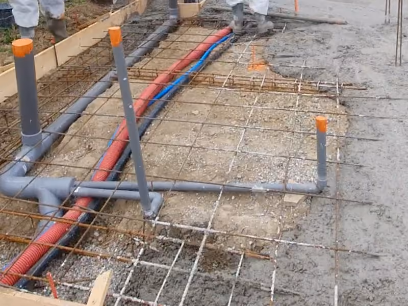 Tubes et gaines des réseaux en attente dans le ferraillage, avant le coulage de la plage.