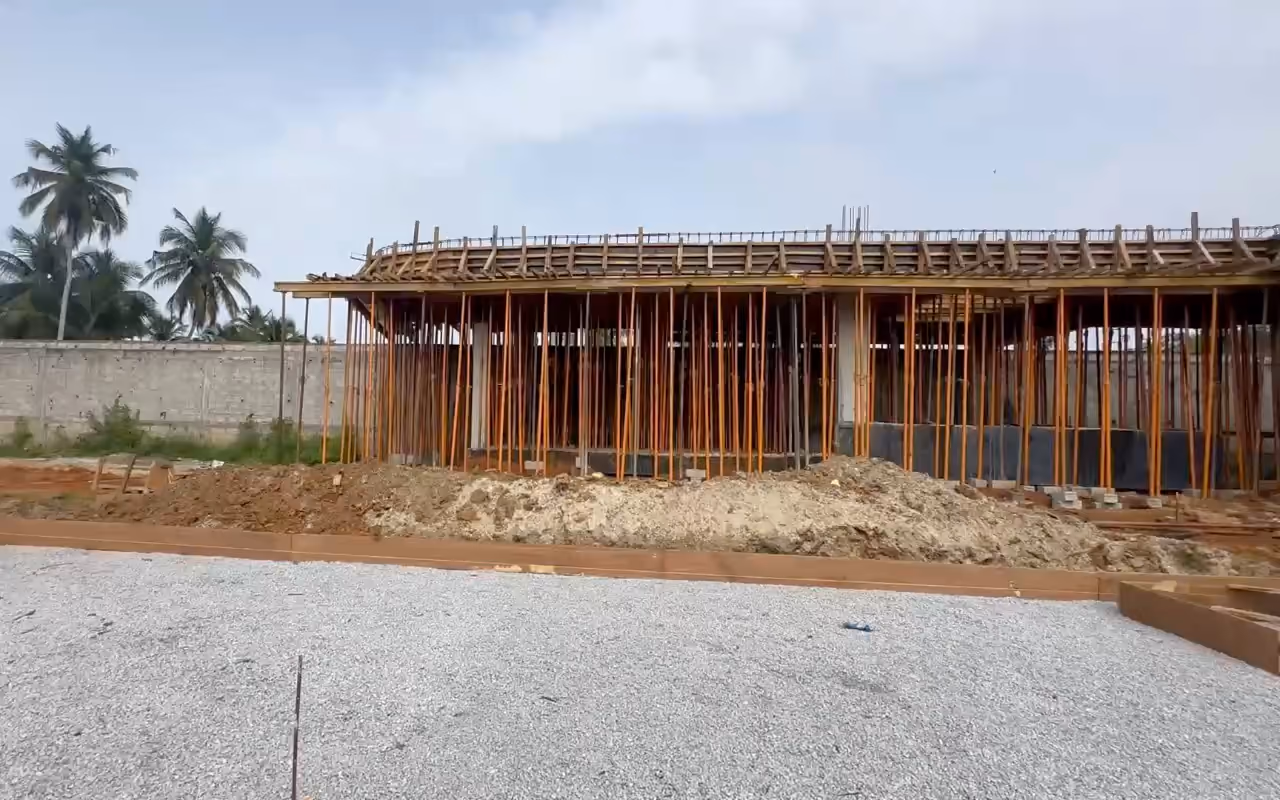 Chantier Villa Park : la structure en béton armé sous ses étais, vue depuis le hérisson de gravier.