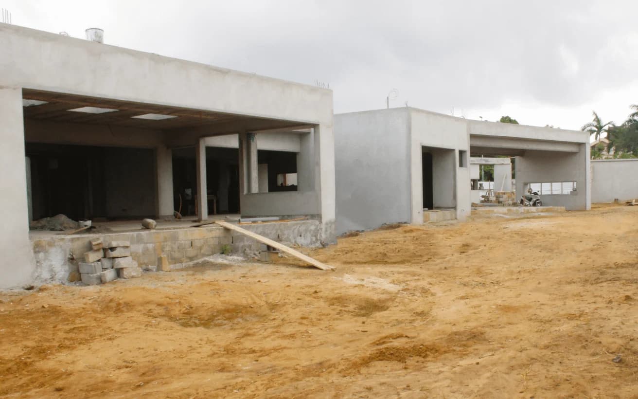 Maisons de plain-pied dont la structure est enduite : les ouvertures attendent leurs menuiseries, le plafond ses luminaires.