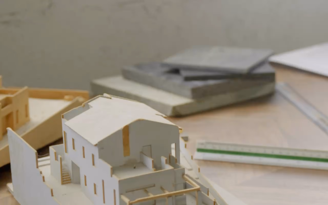 Des plans à la maison : maquette et outils d'architecte, camion-benne qui déverse la terre, béton coulé, patio d'une villa avec piscine.
