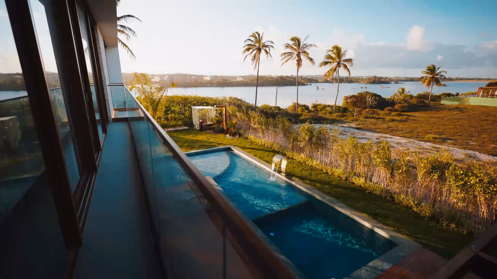 Villas contemporaines avec piscine : vue d'un balcon sur la piscine et une lagune, villa à étage et son bassin, toit-terrasse d'une villa au-dessus d'un quartier.